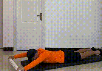 Prone man pulling a towel toward hips - home back training