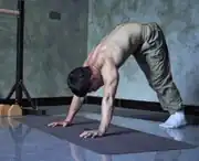 Man doing pike push-up in a shoulder workout at home without equipment.