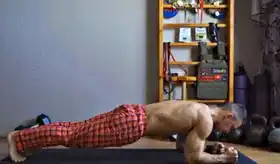Man doing high-to-low plank in a shoulder workout no equipment.
