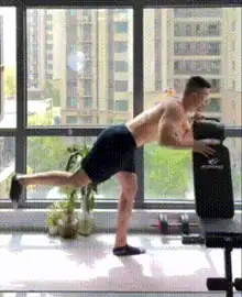 Man performs a Bent-Over standing glute kickback in a calisthenics leg workout.