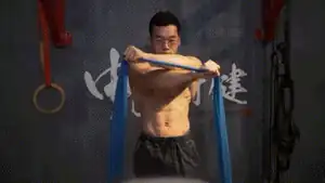 Man performing crossed-arm resistance band chest fly for training inner chest.