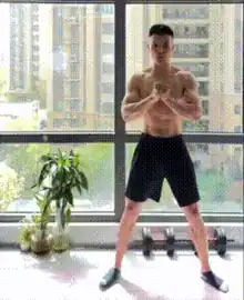 Man stays low during a lateral squat walk for leg workout no equipment.