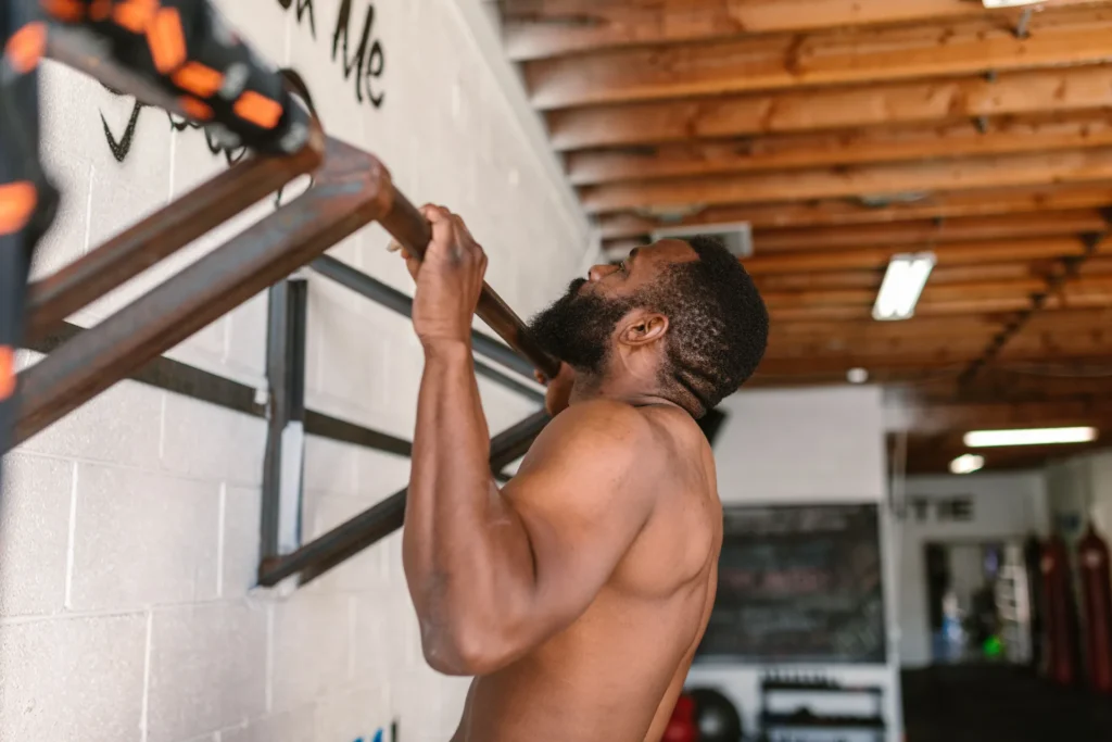 Man performing a pull-up exercise targeting lat workouts and latissimus dorsi muscle development.