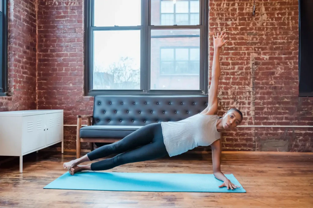 A woman holding elevated side plank, toned obliques built from targeted oblique exercises