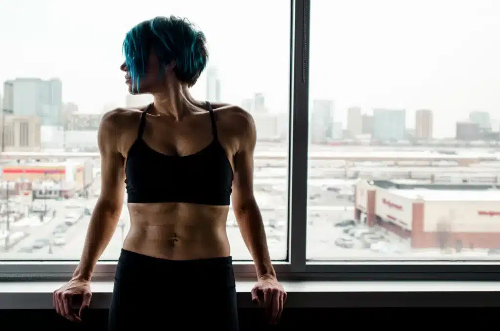 A muscular woman leans against the window.