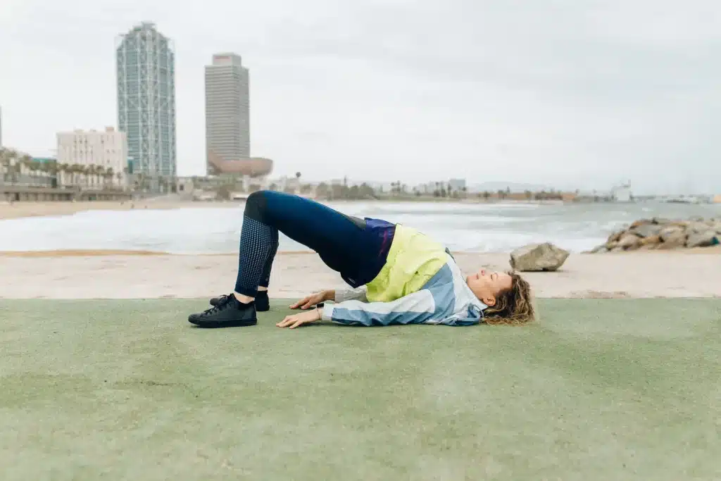A woman performing the hamstring walkout, one of the semitendinosus exercises.