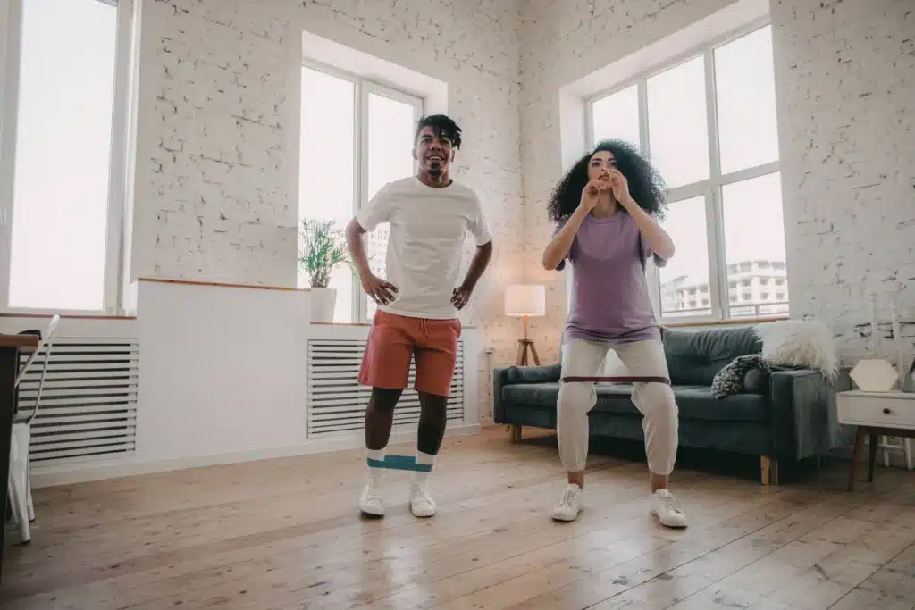 Two people are doing lateral band walks to train their glutes.