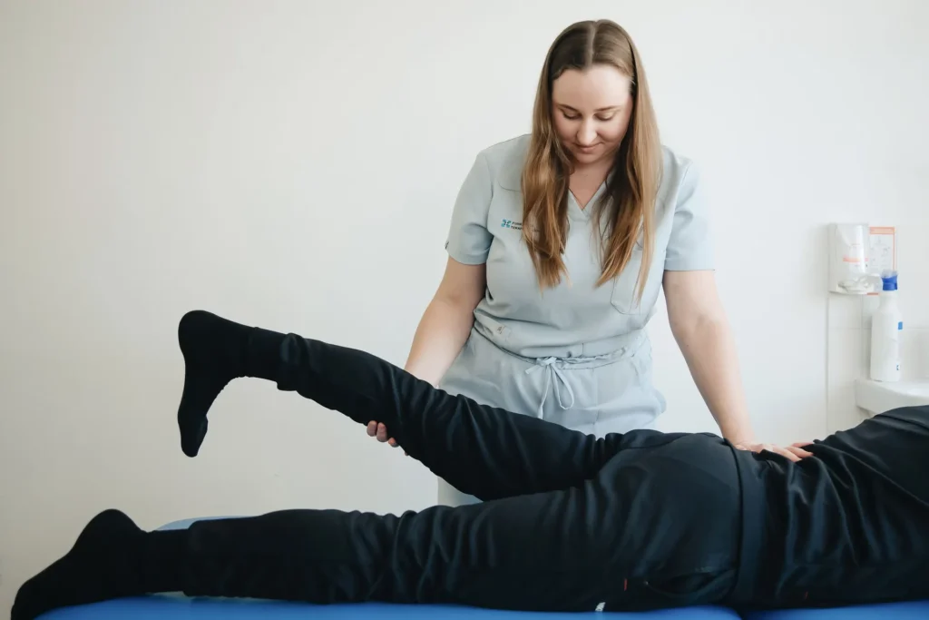 Prone Hip Abduction as effective gluteus minimus exercises, trainer adjusting leg position for steady pelvic and hip control