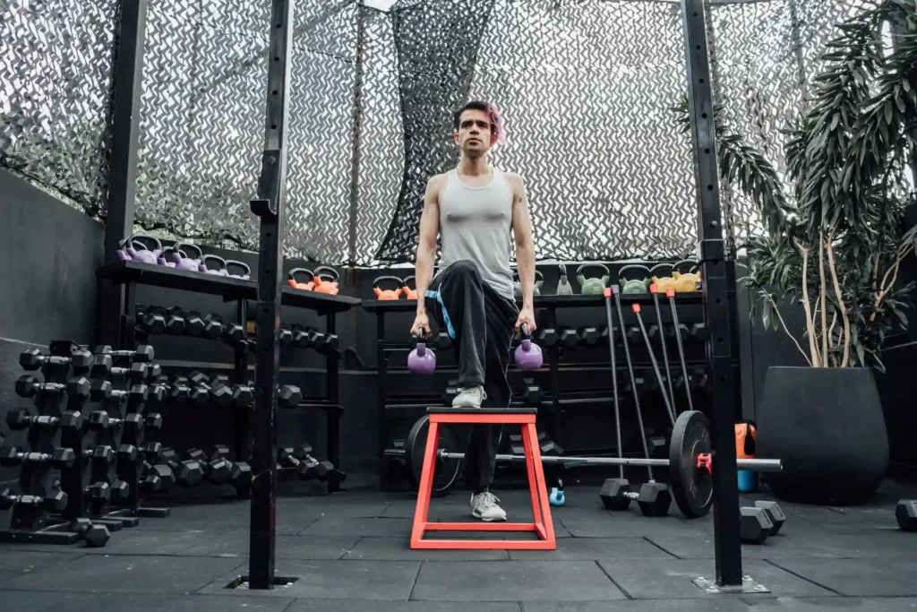 Man performs Step-Up with Top Lockout, one of the effective Vastus Medialis Exercises