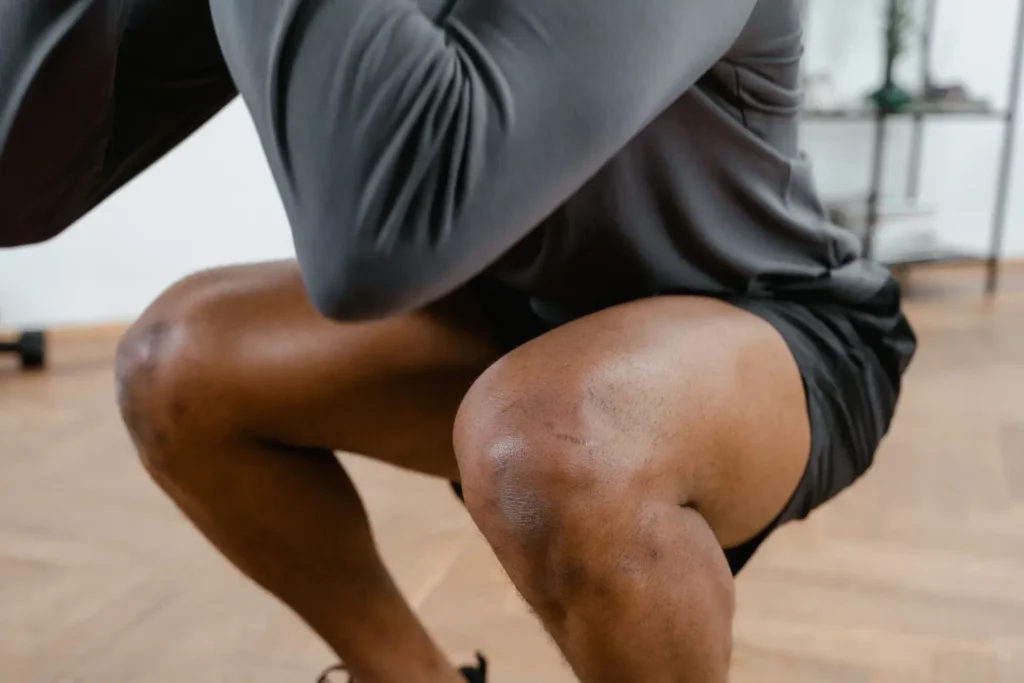 A man is doing squats at home.